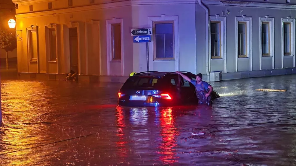 14 September 2024, Austria, Zwettl: A man leans on a car submerged in flood water. Due to heavy rainfall, the whole of Lower Austria was declared a disaster area on 15 September. Photo: Doku-N&ouml;/APA/dpa