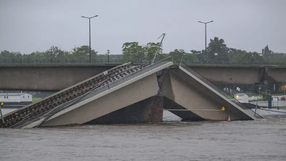 16 September 2024, Saxony, Dresden: The flooding Elbe flows along the partially collapsed Carola Bridge. According to the Saxon state capital, parts of the bridge in the water will cause the water to build up upstream, causing the water level on a section of the Elbe to rise by around 30 to 50 centimetres. Photo: Robert Michael/dpa