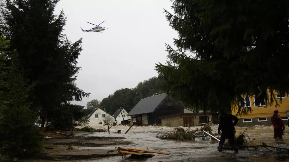 A helicopter hovers over flooded houses in Jesenik, Czech Republic, Sunday, Sept. 15, 2024. (AP Photo/Petr David Josek)