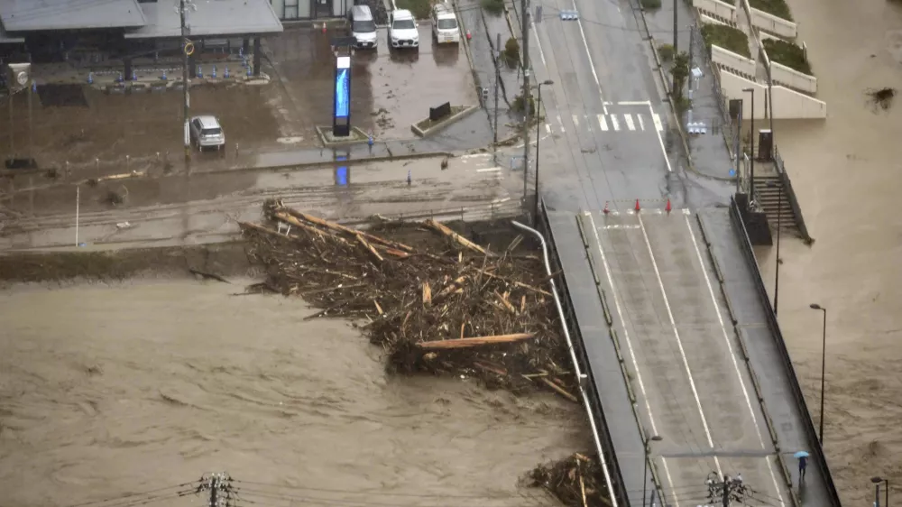 This aerial photo shows driftwoods piled around a bridge, caused by heavy rain in Wajima, Ishikawa prefecture, Saturday, Sept. 21, 2024. (Kyodo News via AP)