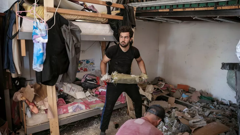 People clean debris from a damaged house amid ongoing search for survivors, a day after an Israeli strike on residential buildings in Maaysra, north of Beirut, Lebanon, September 26, 2024. REUTERS/Louisa Gouliamaki / Foto: Louisa Gouliamaki