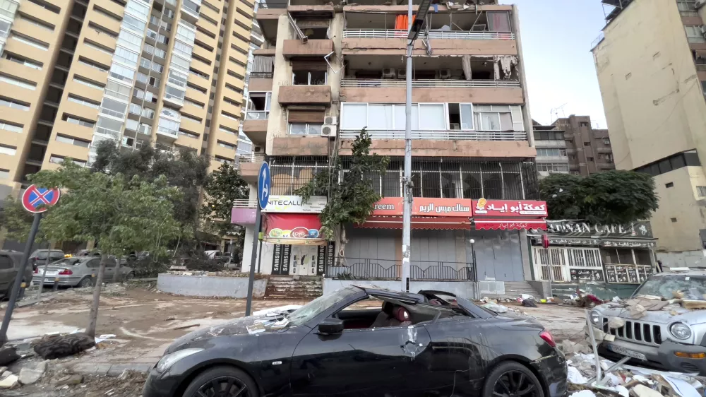 Damaged cars are parked in front of a building that was hit by an Israeli airstrike early Monday, Sept. 30, 2024. (AP Photo/Hussein Malla)