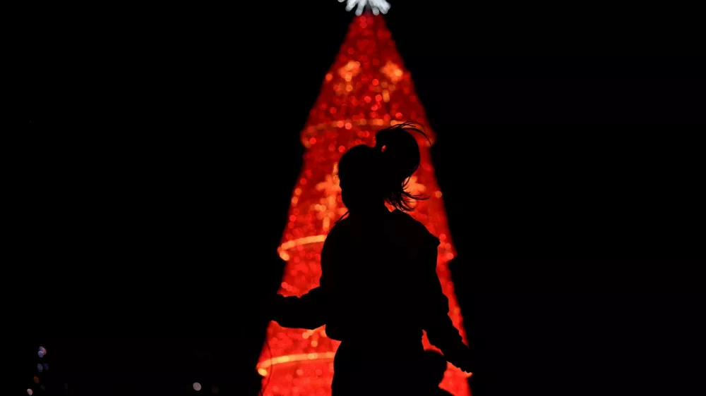 A woman jumps ropes in front of a Christmas tree, as the Christmas season kicks off as per a decree of Venezuela's President Nicolas Maduro, in Caracas, Venezuela October 1, 2024. REUTERS/Gaby Oraa   TPX IMAGES OF THE DAY