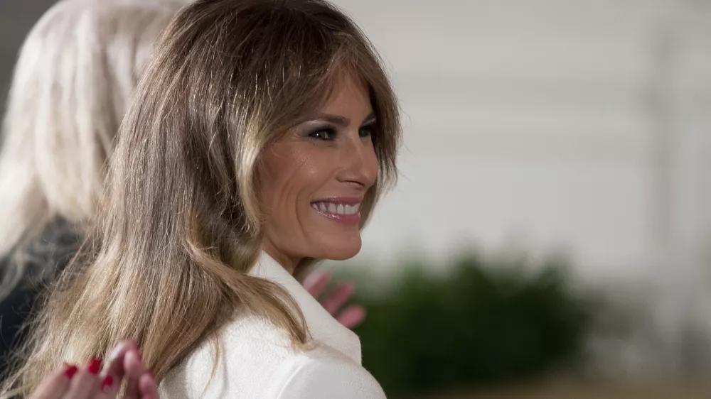 FILE - This is a Wednesday, March 29, 2017, file photo of U.S. first lady Melania Trump smiles as she is recognized by President Donald Trump as he speaks at a women's empowerment panel, in the East Room of the White House in Washington. Melania Trump on Wednesday April 12, 2017, accepted an apology and damages from the publisher of the Daily Mail newspaper for reporting rumors about her time as a model. (AP Photo/Andrew Harnik, File)