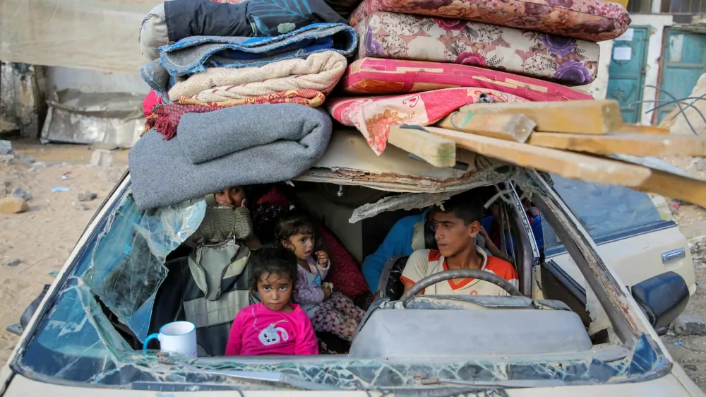Displaced Palestinians sit in a damaged car as they flee areas in the eastern part of Khan Younis following an Israeli evacuation order, amid the ongoing conflict between Israel and Hamas, in Khan Younis in the southern Gaza Strip October 7, 2024. REUTERS/Hatem Khaled   TPX IMAGES OF THE DAY