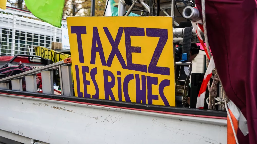 France, Paris, 2024/10/01. Inter-professional demonstration in Paris and throughout France for wages, public services and the repeal of pension reform. A sign reading tax the rich on a lorry. Photography by Myriam Tirler / Hans Lucas.France, Paris, 2024/10/01. Manifestation interprofessionelle Paris et dans toute la France pour les salaires, les services publics et l'abrogation de la reforme des retraites. Une pancarte ou est ecrit taxez les riches sur un camion. Photographie de Myriam Tirler / Hans Lucas.