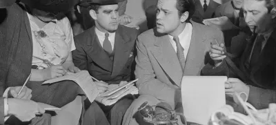 Fotografija je nastala 31. oktobra 1938, ko so Orsona Wellsa obkrožili novinarji, da jim pojasni zaplet okrog radijske igre Vojna svetov, ki je povzročila vsesplošno paniko med poslušalci. / Foto: Wikipedija / Foto: Wikipedija