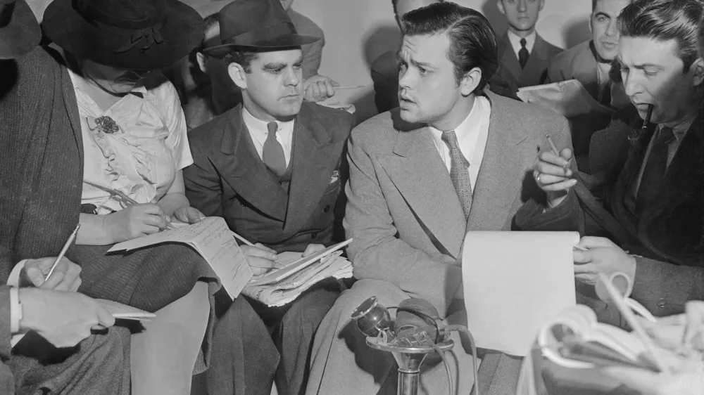 Fotografija je nastala 31. oktobra 1938, ko so Orsona Wellsa obkrožili novinarji, da jim pojasni zaplet okrog radijske igre Vojna svetov, ki je povzročila vsesplo&scaron;no paniko med poslu&scaron;alci. / Foto: Wikipedija / Foto: Wikipedija