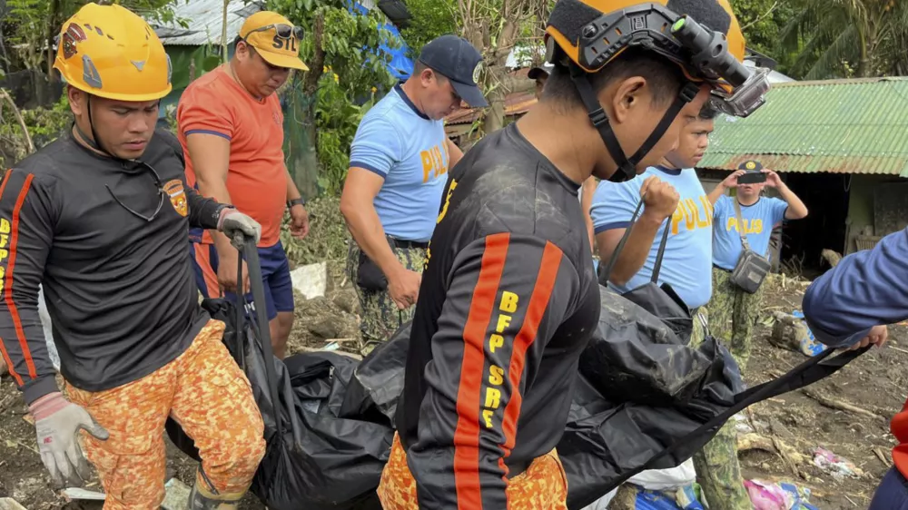 Rescuers carry a body during retrieval operations after a landslide triggered by Tropical Storm Trami, struck homes in Talisay, Batangas province, Philippines, Saturday, Oct. 26, 2024. (AP Photo/Jim Gomez)