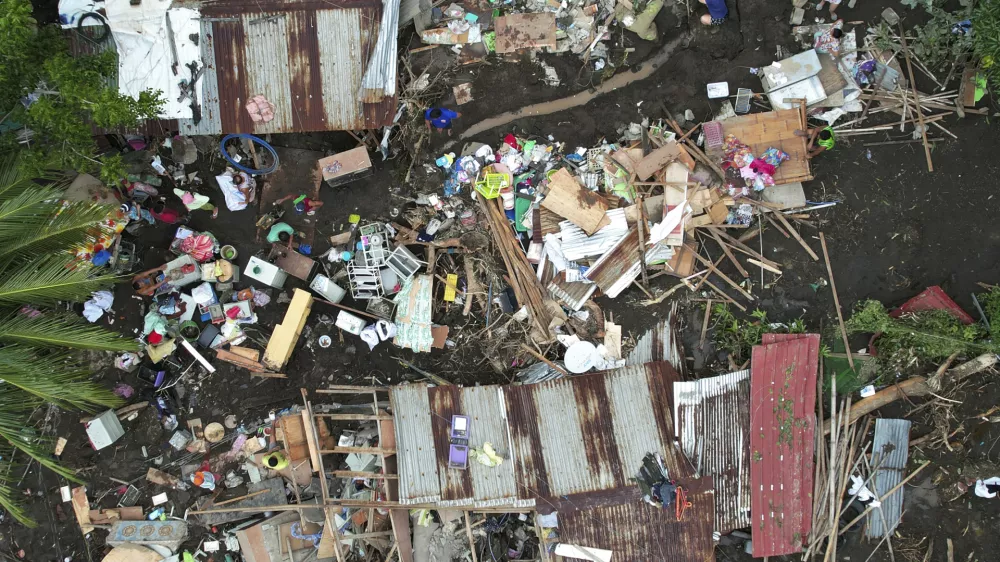 Residents gather what they can from their damaged homes on Saturday, Oct. 26, 2024 after being struck by a landslide triggered by Tropical Storm Trami in Talisay, Batangas province, Philippines. (AP Photo/Aaron Favila)