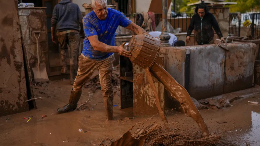 A man cleans his house affected by floods in Utiel, Spain, Wednesday, Oct. 30, 2024. (AP Photo/Manu Fernandez)