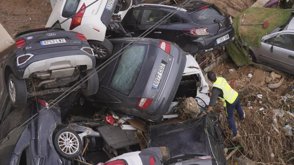 A civil guard seaches for survivors in cars piled up on the outskirts of Valencia, Spain, Friday, Nov. 1, 2024 after flooding. (AP Photo/Alberto Saiz)