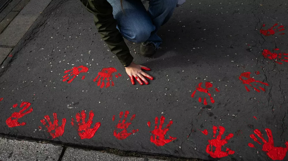Demonstrators leave red hand prints on a sidewalk as they protest to commemorate an accident at a railway station in the Serbian city of Novi Sad, for which they blame negligence and corruption by the authorities, in front of the government in Belgrade, Serbia November 3, 2024. REUTERS/Marko Djurica