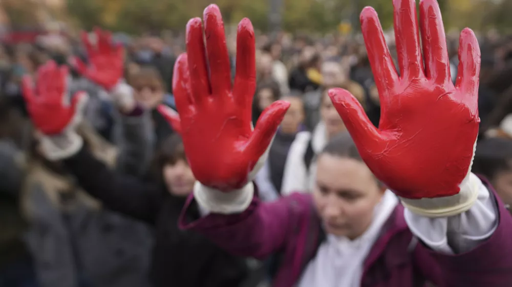 Protesters shout slogans with red paint on thire hands symbolizing blood, demanding arrests, two days after a concrete canopy collapsed at a railway station in Novi Sad, killing 14 people and injuring three, during a protest in Belgrade, Serbia, Sunday, Nov. 3, 2024. (AP Photo/Darko Vojinovic)