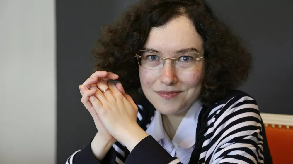 In this photo taken Wednesday, March 22, 2017, Russian journalist-in-exile Kseniya Kirillova poses in a lobby near her home in Oakland, Calif. Teasing out clues from thousands of miles away, Kirillova works the phone and internet in her Oakland apartment to report on alleged clandestine campaigns by her home country, Russia, to disrupt the affairs of the nations around it. These days, the 34-year-old's work has drawn closer, to her new home, the United States, where Congress and the FBI are investigating what U.S. intelligence agencies say was Russian interference in the 2016 presidential race. (AP Photo/Eric Risberg)