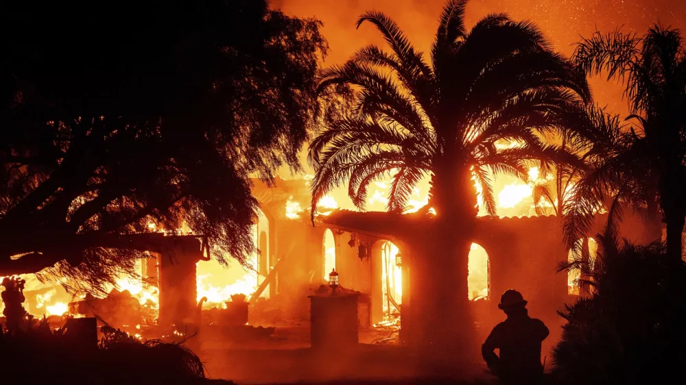 A firefighter watches as flames from the Mountain Fire consume a home in Camarillo, Calif., Nov. 6, 2024. (AP Photo/Noah Berger)
