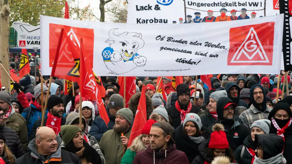 21 November 2024, Lower Saxony, Wolfsburg: Volkswagen employees demonstrate in front of the Volkswagen Arena in Wolfsburg during the wage negotiations between Volkswagen and IG Metall. IG Metall welcomes the Group representatives to the third round of collective bargaining with a loud protest. Photo: Alicia Windzio/dpa