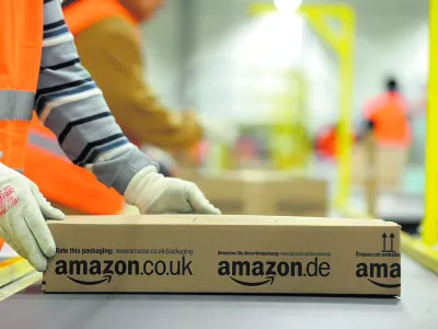 FILE - In this Dec. 11, 2012 file photo an employee of Amazon works at the company's logistic center in Pforzheim, Germany. Online retailer Amazon reacted to mounting criticism Monday, Feb. 18, 2013, by firing a security company named in a German television documentary about alleged mistreatment of foreign temporary workers. An Amazon spokeswoman in Germany said the company had ended its relationship with Hensel European Security Services "with immediate effect." (AP Photo/dpa, Jan-Philipp Strobel)