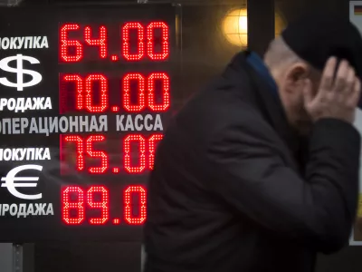 Signs advertising currencies light next to the exchange office in Moscow, Russia, Tuesday, Dec. 16, 2014. After a massive overnight rate hike by Russia's Central Bank, the ruble staged a two-hour rally Tuesday morning before rolling back to new historic lows. The surprise Central Bank decision to raise the rate to 17 percent from 10.5 percent came in the early hours on Tuesday in a desperate attempt to prop up the troubled currency. It's the biggest interest rate hike since 1998, the year when Russia defaulted on its sovereign bonds.(AP Photo / Alexander Zemlianichenko)