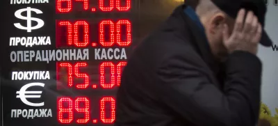Signs advertising currencies light next to the exchange office in Moscow, Russia, Tuesday, Dec. 16, 2014. After a massive overnight rate hike by Russia's Central Bank, the ruble staged a two-hour rally Tuesday morning before rolling back to new historic lows. The surprise Central Bank decision to raise the rate to 17 percent from 10.5 percent came in the early hours on Tuesday in a desperate attempt to prop up the troubled currency. It's the biggest interest rate hike since 1998, the year when Russia defaulted on its sovereign bonds.(AP Photo / Alexander Zemlianichenko)