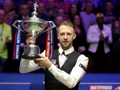 Britain's Judd Trump lifts the trophy after winning the 2019 Snooker World Championship after beating Scotland's John Higgins, at The Crucible, in Sheffield, England, Monday May 6, 2019. (Richard Sellers/PA via AP)