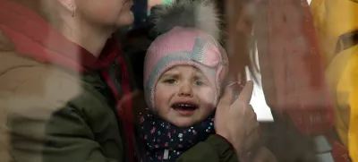 A Ukrainian refugees child reacts as he boards a bus after arriving at Hendaye train station, southwestern France, Wednesday, March 9, 2022. About 200 Ukrainian refugees are arriving in the French Atlantic coast town of Hendaye, where local authorities are greeting them in the train station and offering them temporary lodging. They are among 2 million people, mostly women and children, who have fled fighting in Ukraine since Russia's invasion two weeks ago and are seeking refuge around Europe.(AP Photo/Bob Edme)