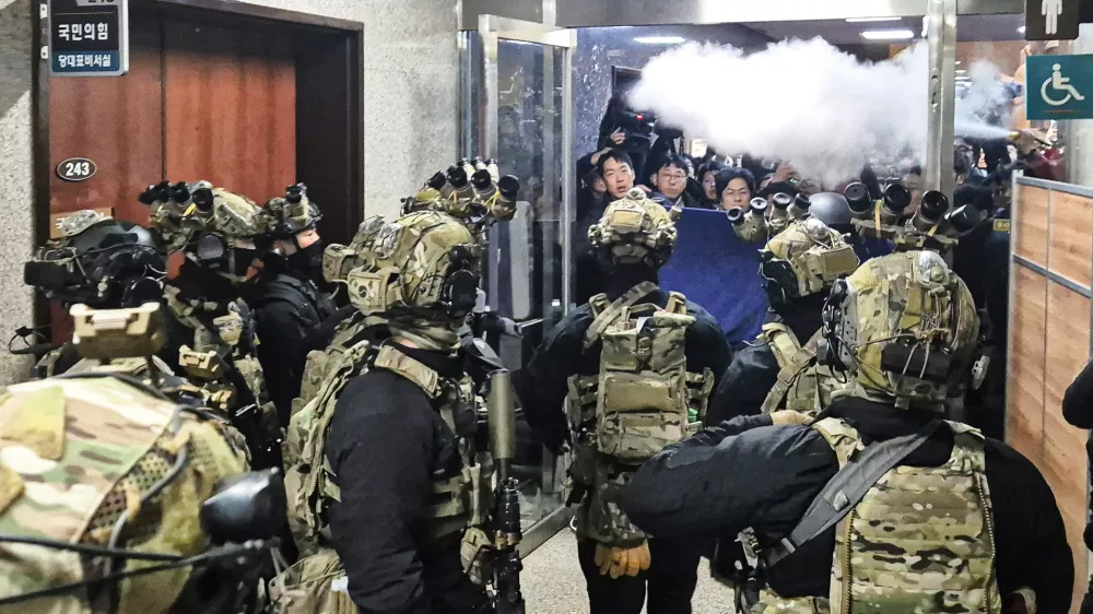 V južnokorejskem parlamentu so posku&scaron;ali preprečiti vstop varnostnim silam tudi z uporabo gasilnih aparatov. Foto: AP