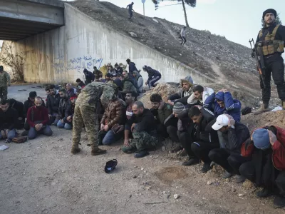 Government soldiers and allies sit on the floor as they are taken into custody by opposition fighters on the road between Homs and Damascus, near Homs, Syria, on Sunday, Dec. 8, 2024. (AP Photo/Ghaith Alsayed)