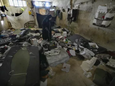 A woman looks at a room of the infamous Saydnaya military prison, just north of Damascus, Syria, Monday, Dec. 9, 2024. Crowds are gathering to enter the prison, known as the "human slaughterhouse," after thousands of inmates were released following the rebels' overthrow of Bashar al-Assad's regime on Sunday. (AP Photo/Hussein Malla)