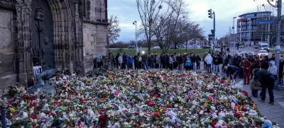 People lay flowers and lit candles in front of the Johannis church close to the Christmas market, where a car drove into a crowd on Friday evening, in Magdeburg, Germany, Sunday, Dec. 22, 2024. (AP Photo/Ebrahim Noroozi)