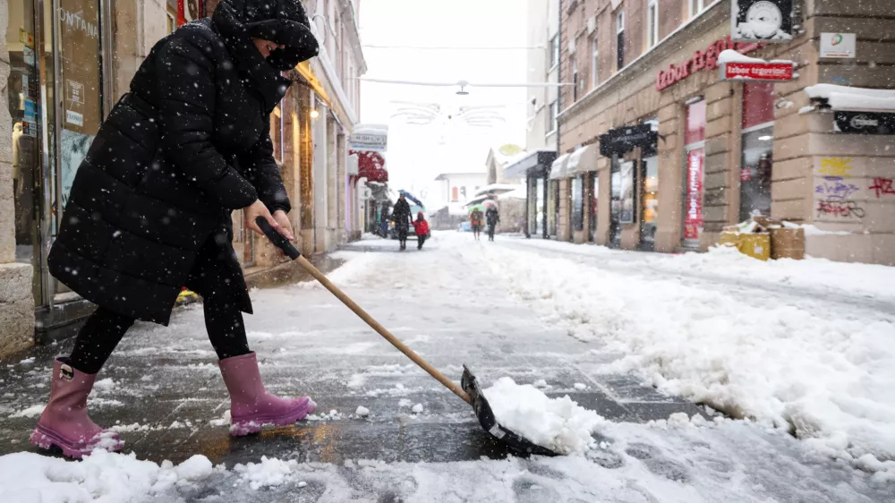 Ker so ob obilnem sneženju zatajile komunalne službe, so v mestih (na fotografiji Sarajevo) in vaseh ljudje sami poprijeli za snežne lopate ter se organizirali pri či&scaron;čenju cest in ulic. Foto: Reuters
