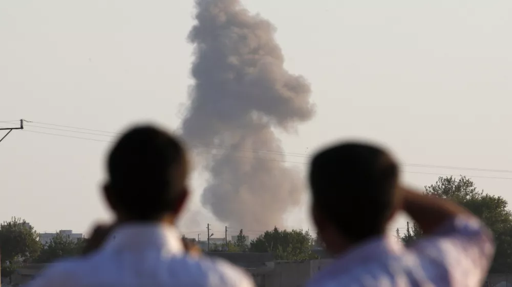 Turkish Kurds standing on the outskirts of Suruc, on the Turkey-Syria border, watch smoke rise following an airstrike in Kobani, Syria, where the fighting between militants of the Islamic State group and Kurdish forces intensified, Tuesday, Oct. 7, 2014. Kobani, also known as Ayn Arab and its surrounding areas have been under attack since mid-September, with militants capturing dozens of nearby Kurdish villages. (AP Photo/Lefteris Pitarakis)