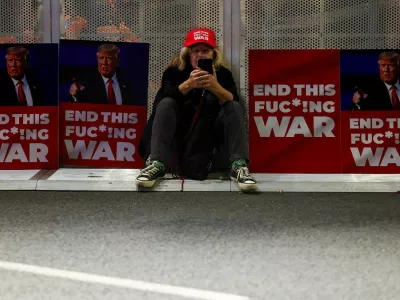 FILE PHOTO: A woman sits between placards with pictures of U.S. President-elect Donald Trump, on the day of a protest against the government and to show support for the hostages who were kidnapped during the deadly October 7, 2023 attack, amid the conflict in Gaza between Israel and Hamas, in Tel Aviv, Israel January 11, 2025. REUTERS/Kai Pfaffenbach/File Photo