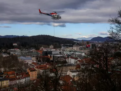 - Helikopter z privezanim drevesom in potni&scaron;ko letalo,- drevo v zraku, leteče drevo,- 13.01.2024. - Sečnja in spravilo oslabljenega lesa na Grajskem hribu v Ljubljani tudi s helikopterjem prvič v Sloveniji.//FOTO: Bojan Velikonja