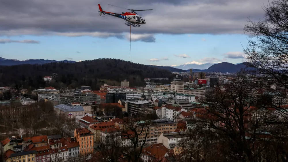 - Helikopter z privezanim drevesom in potni&scaron;ko letalo,- drevo v zraku, leteče drevo,- 13.01.2024. - Sečnja in spravilo oslabljenega lesa na Grajskem hribu v Ljubljani tudi s helikopterjem prvič v Sloveniji.//FOTO: Bojan Velikonja