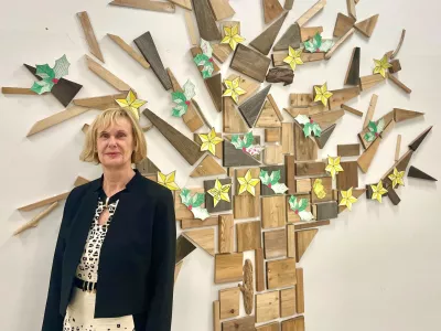 Mag. Đulijana Juričić, ravnateljica O&Scaron; Trnovo, pred drevesom pohval, ki so ga učenci in zaposleni na &scaron;oli lepo sprejeli. / Foto: Tja&scaron;a Lampret