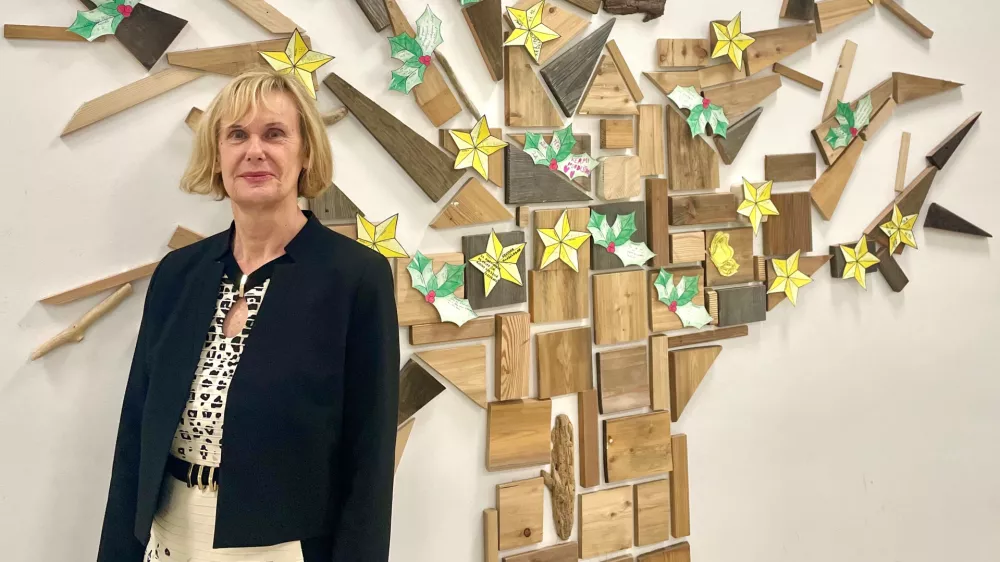 Mag. Đulijana Juričić, ravnateljica O&Scaron; Trnovo, pred drevesom pohval, ki so ga učenci in zaposleni na &scaron;oli lepo sprejeli. / Foto: Tja&scaron;a Lampret