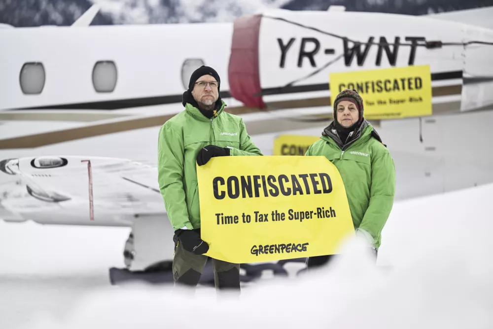 Greenpeace activists stage a protest asking for higher taxes for the super-rich people, on the sideline of the 55th annual meeting of the World Economic Forum (WEF), in Samedan, Switzerland, Wednesday, Jan. 22, 2025. (Gian Ehrenzeller/Keystone via AP)