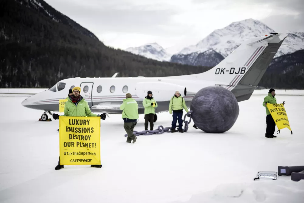 Greenpeace activists stage a protest asking for higher taxes for the super-rich people, on the sideline of the 55th annual meeting of the World Economic Forum (WEF), in Samedan, Switzerland, Wednesday, Jan. 22, 2025. (Gian Ehrenzeller/Keystone via AP)