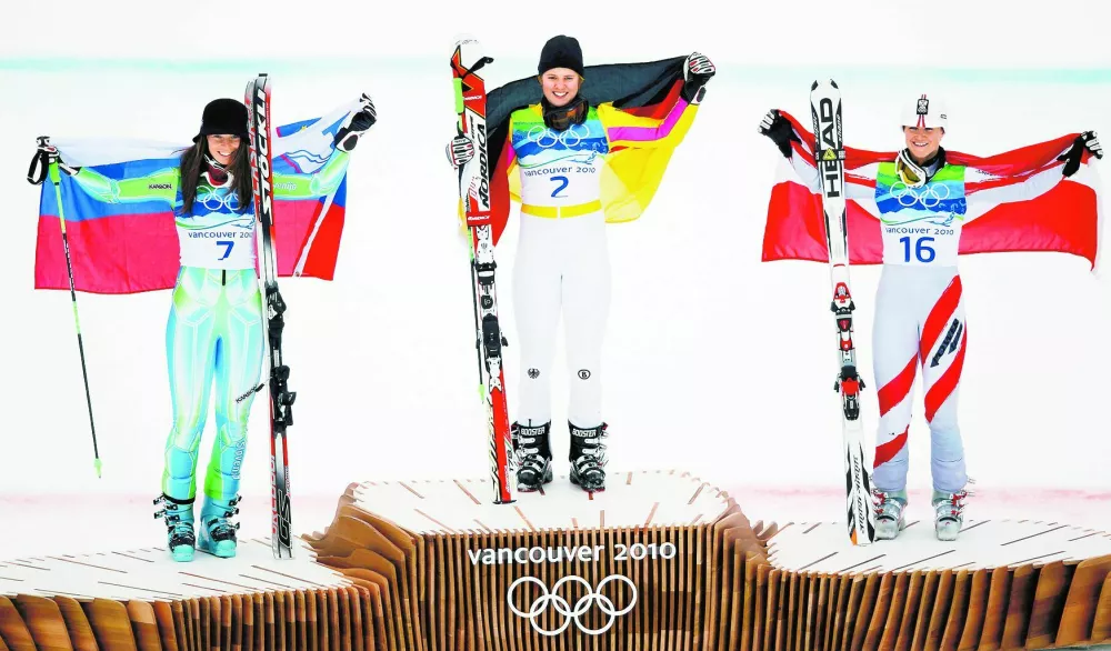 From L-R, silver medallist Slovenia's Tina Maze, gold medallist Germany's Viktoria Rebensburg and bronze medallist Austria's Elisabeth Goergl hold national flags as they celebrate on the podium during the flower ceremony for the women's alpine skiing giant slalom event at the Vancouver 2010 Winter Olympics in Whistler, British Columbia, February 25, 2010. REUTERS/Wolfgang Rattay (CANADA).------.?tiri kol barve / Foto: Reuters