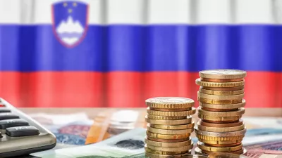 Euro banknotes and coins in front of the national flag of Slovenia / Foto: Zerbor