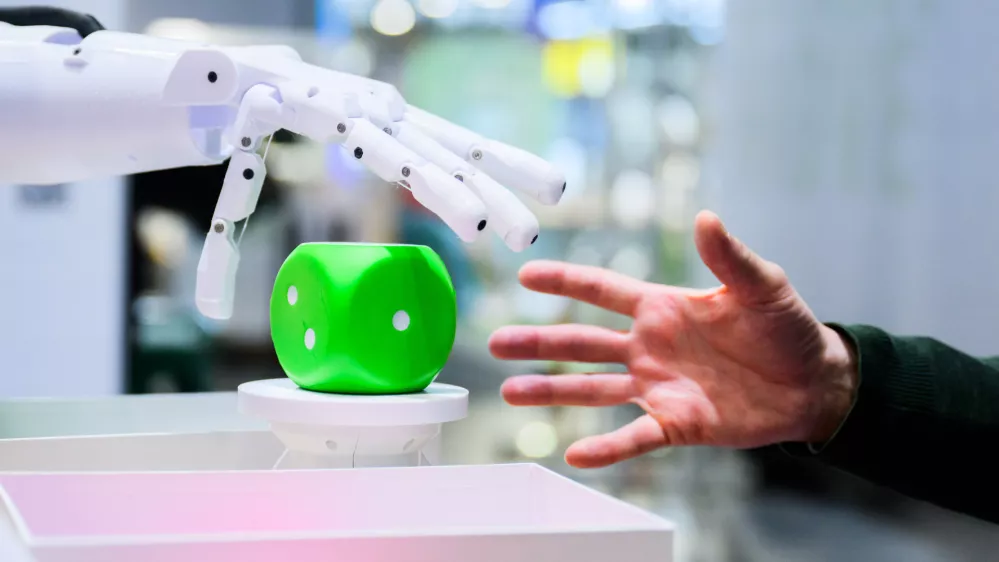 Na industrijskem sejmu v nem&scaron;kem Hannovru mo&scaron;ki komunicira z robotom iz učne platforme pib@school&nbsp;za robotiko, 3D-tiskanje in umetno inteligenco, ki učencem nudi praktične izku&scaron;nje na teh področjih.&nbsp;/ Foto: dpa