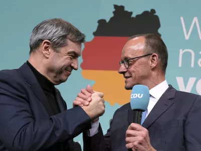 Voditelja zmagovalnega dvojčka CDU/CSU Friedrich Merz (desno) in Markus S&ouml;der sta se po objavi izidov vzporednih volitev zmagovalno pozdravila. Foto: AP