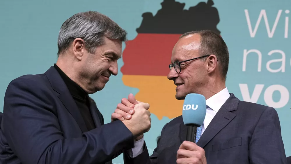 Voditelja zmagovalnega dvojčka CDU/CSU Friedrich Merz (desno) in Markus S&ouml;der sta se po objavi izidov vzporednih volitev zmagovalno pozdravila. Foto: AP