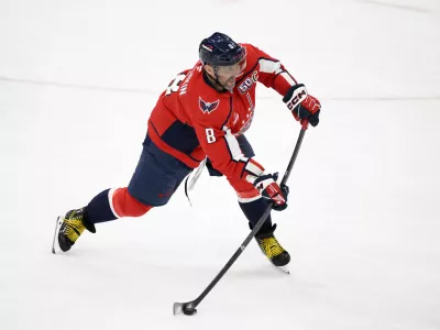 Washington Capitals left wing Alex Ovechkin (8) shoots the puck for an empty net goal and a hat trick during the third period of an NHL hockey game against the Edmonton Oilers, Sunday, Feb. 23, 2025, in Washington. (AP Photo/Nick Wass)