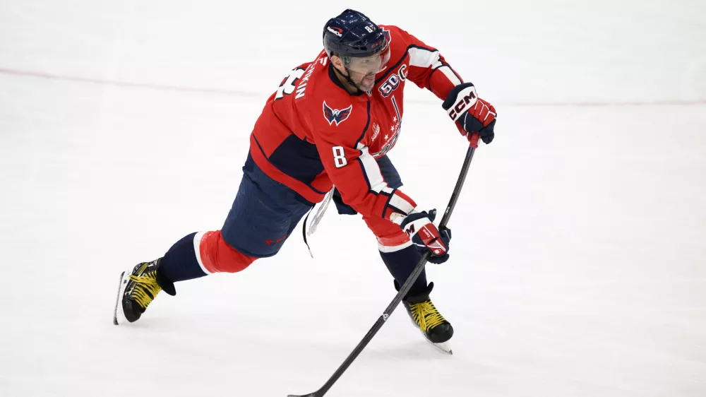 Washington Capitals left wing Alex Ovechkin (8) shoots the puck for an empty net goal and a hat trick during the third period of an NHL hockey game against the Edmonton Oilers, Sunday, Feb. 23, 2025, in Washington. (AP Photo/Nick Wass)