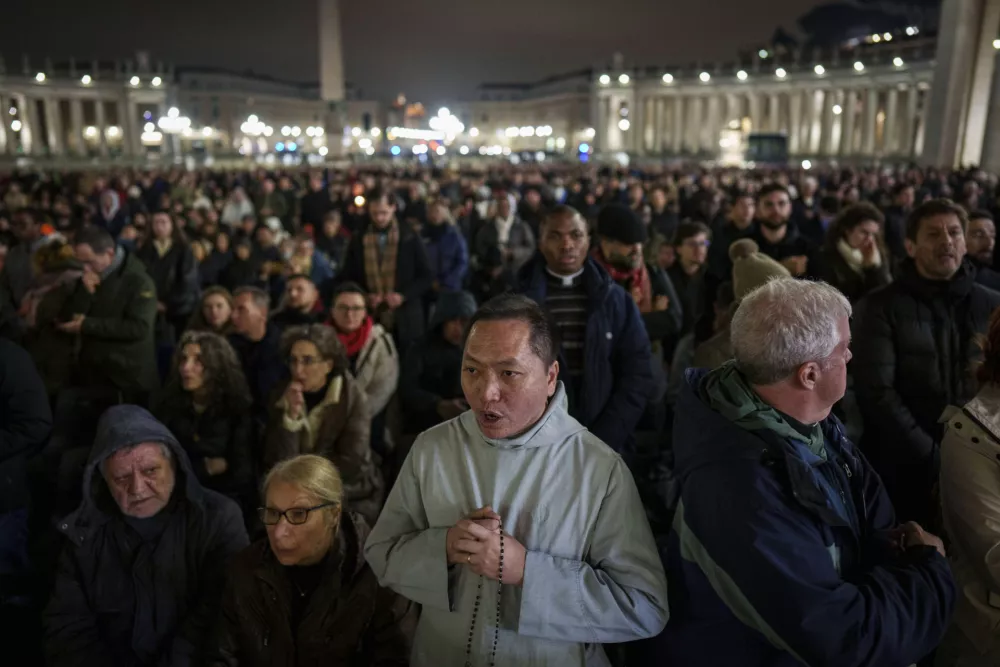 Faithful pray during a nightly rosary in St. Peter's Square at The Vatican for Pope Francis' recovery, Monday, Feb. 24, 2025. (AP Photo/Bernat Armangue)