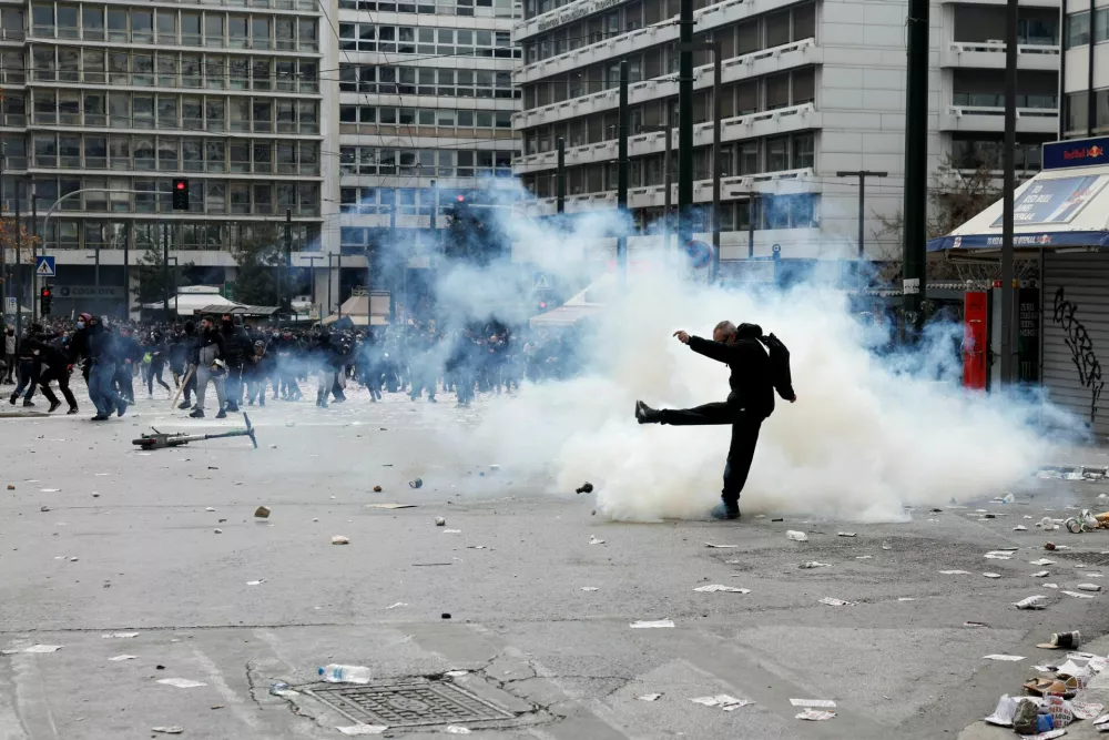 A demonstator reacts to tear gas during clashes with police near the Greek parliament at a protest, marking the second anniversary of the country's worst railway disaster, while an investigation continues, in Athens, Greece, February 28, 2025. REUTERS/Louisa Gouliamaki