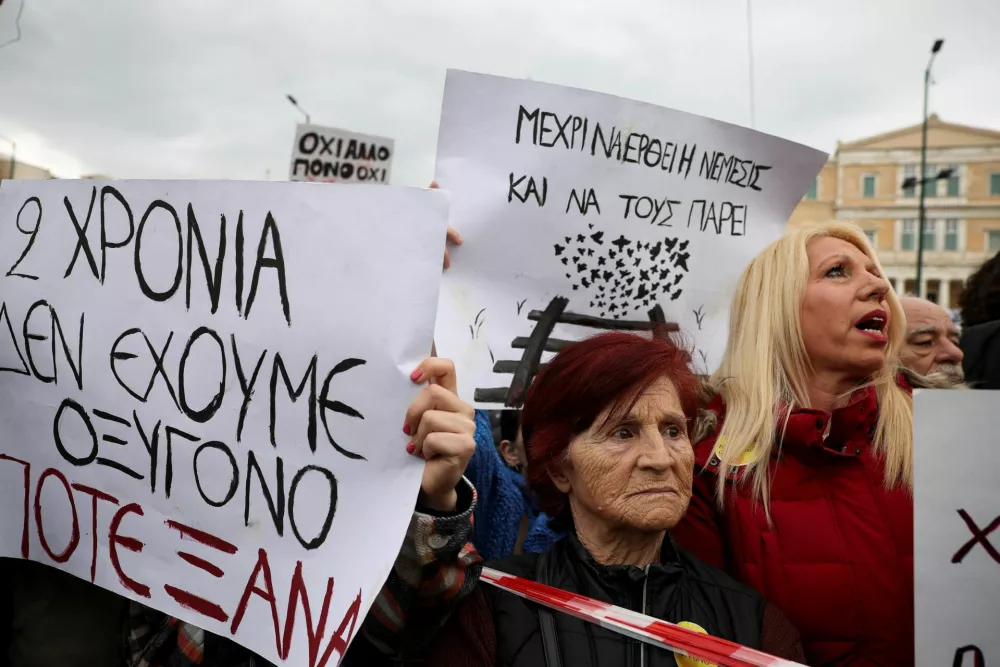 People hold placards in front of the Greek parliament during a protest, marking the second anniversary of the country's worst railway disaster, while an investigation continues, in Athens, Greece, February 28, 2025. REUTERS/Louisa Gouliamaki