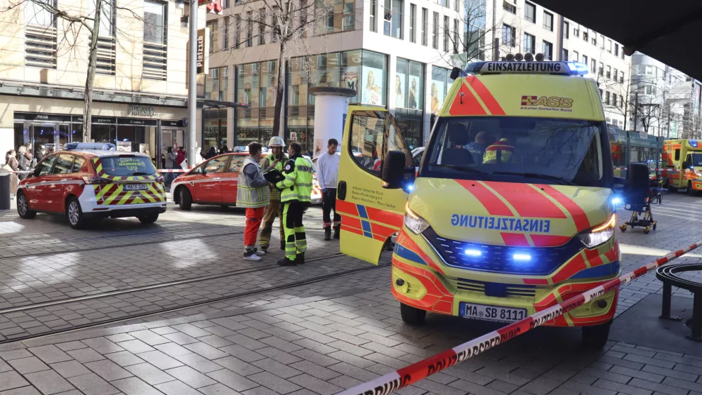 Emergency services and police stand at Paradeplatz in Mannheim, Germany, Monday March 3, 2025, after a driver driver drove into a group of people in a pedestrian street in Mannheim, killing one person and injuring others, Germany police said. (Ren&eacute; Priebe/dpa via AP)(Ren&eacute; Priebe/dpa via AP)